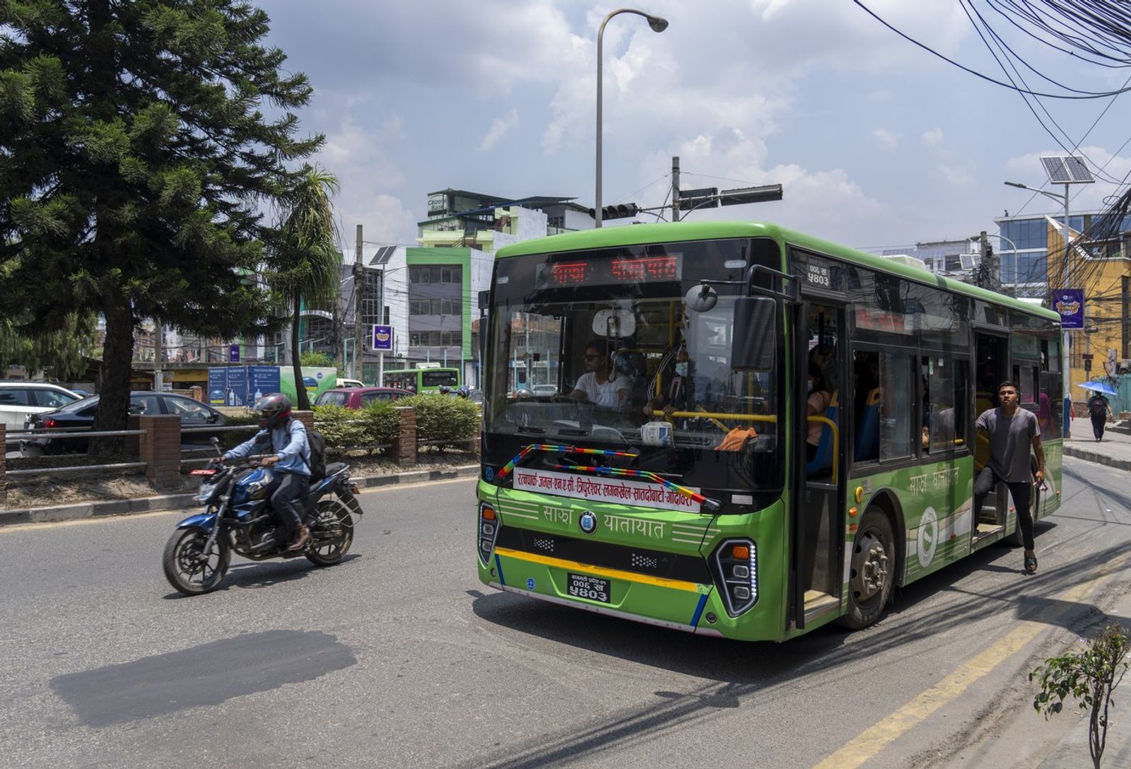 ductor of an electric passenger bus calls to attract attention of the travelers in Kathmandu, Nepal, Wednesday, May 22, 2024. Nepal's abundant hydroelectric power is helping the Himalayan nation cut its oil imports and clean up its air, thanks to a boom in sales of electric vehicles. (AP Photo/Niranjan Shrestha)