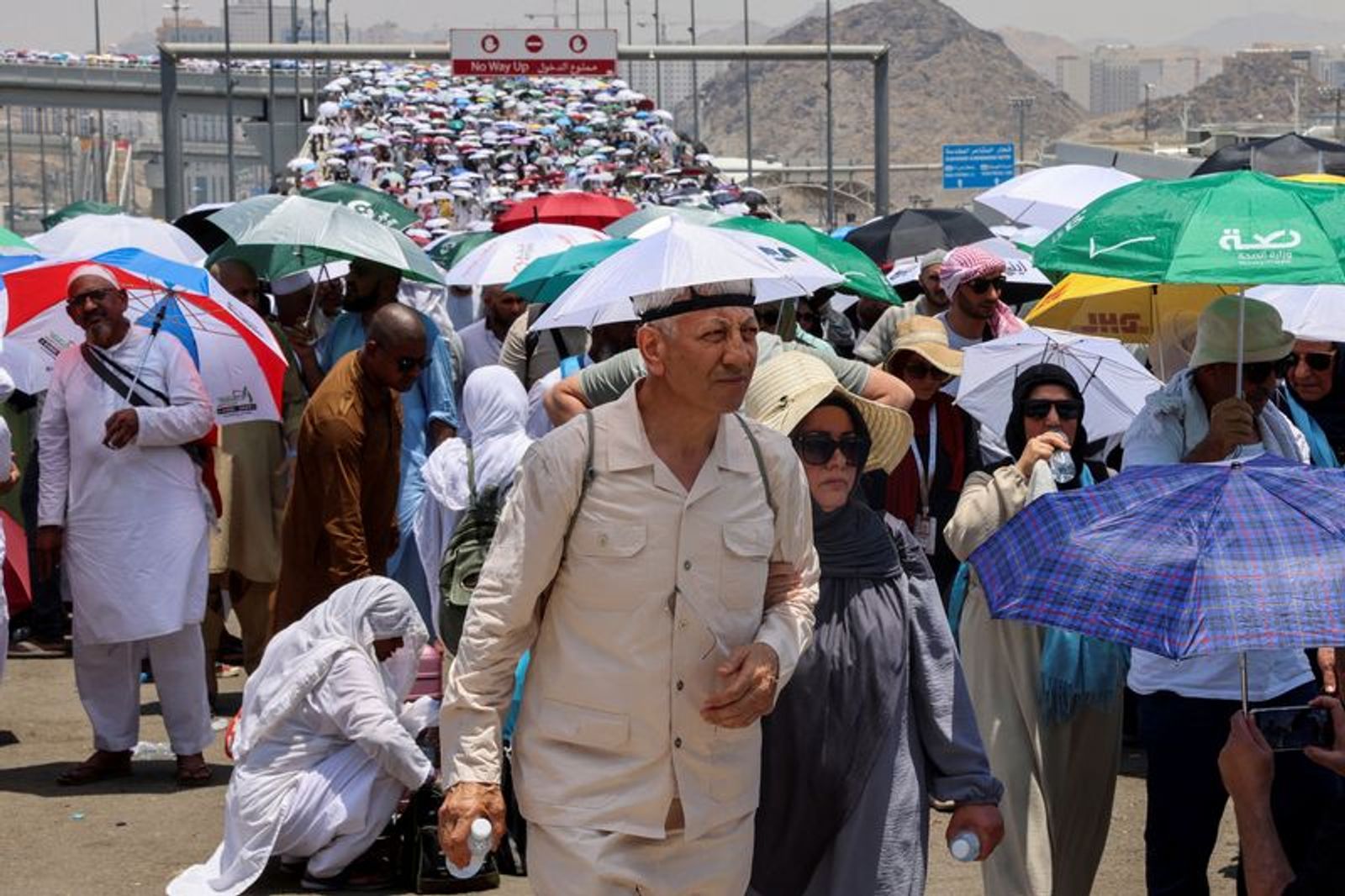 FILE PHOTO: Muslim pilgrims walk with umbrellas on the third day of the Satan stoning ritual, amid extremely hot weather, during the annual haj pilgrimage, in Mina, Saudi Arabia, June 18, 2024. REUTERS/Saleh Salem/File Photo