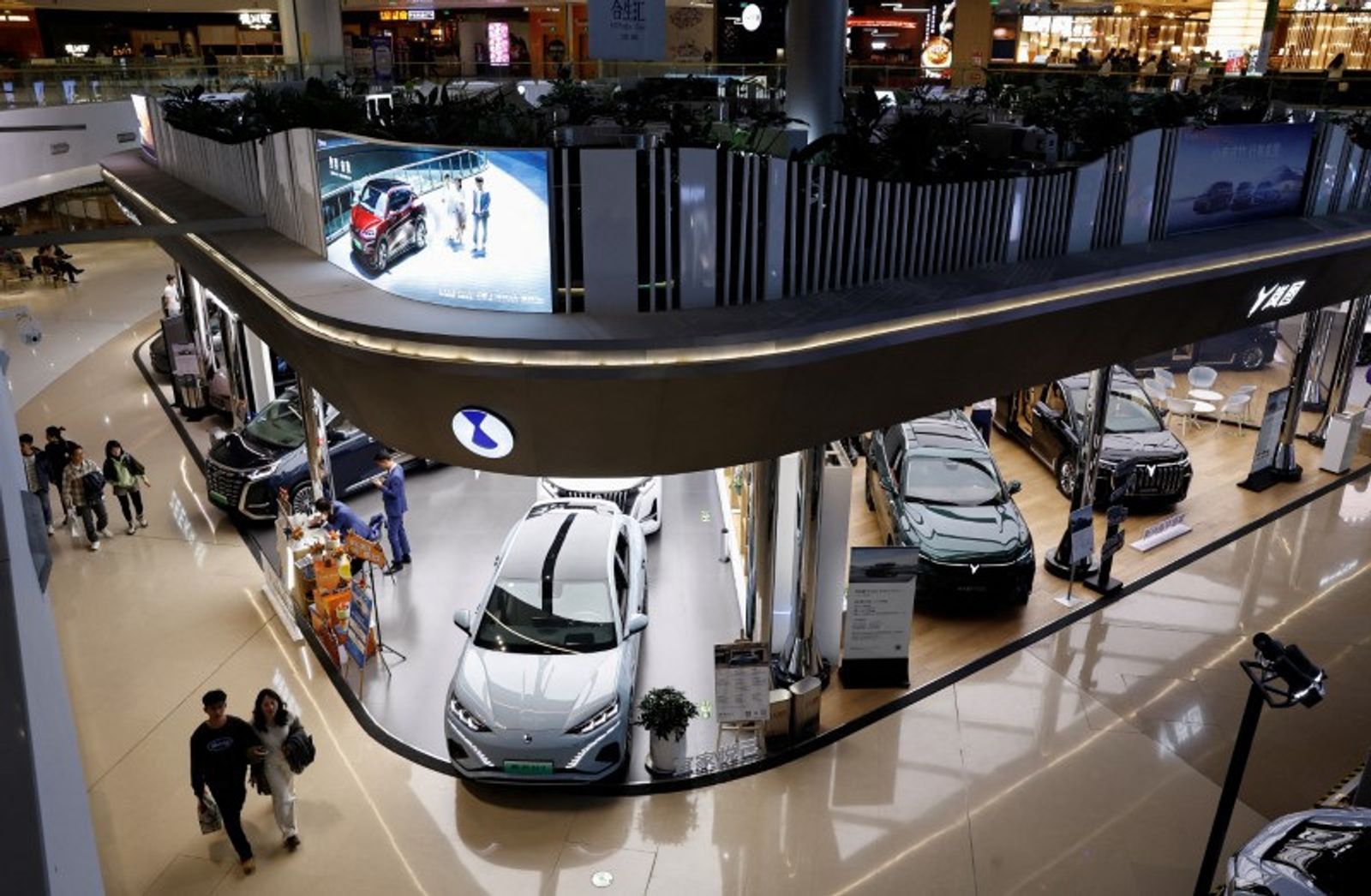 FILE PHOTO: Electric vehicle (EV) models are displayed at the booths of Denza, a joint venture between Mercedes-Benz Group AG and BYD Auto, and Chinese EV maker Voyah, at a shopping mall in Beijing, China November 3, 2023. REUTERS/Tingshu Wang/File Photo