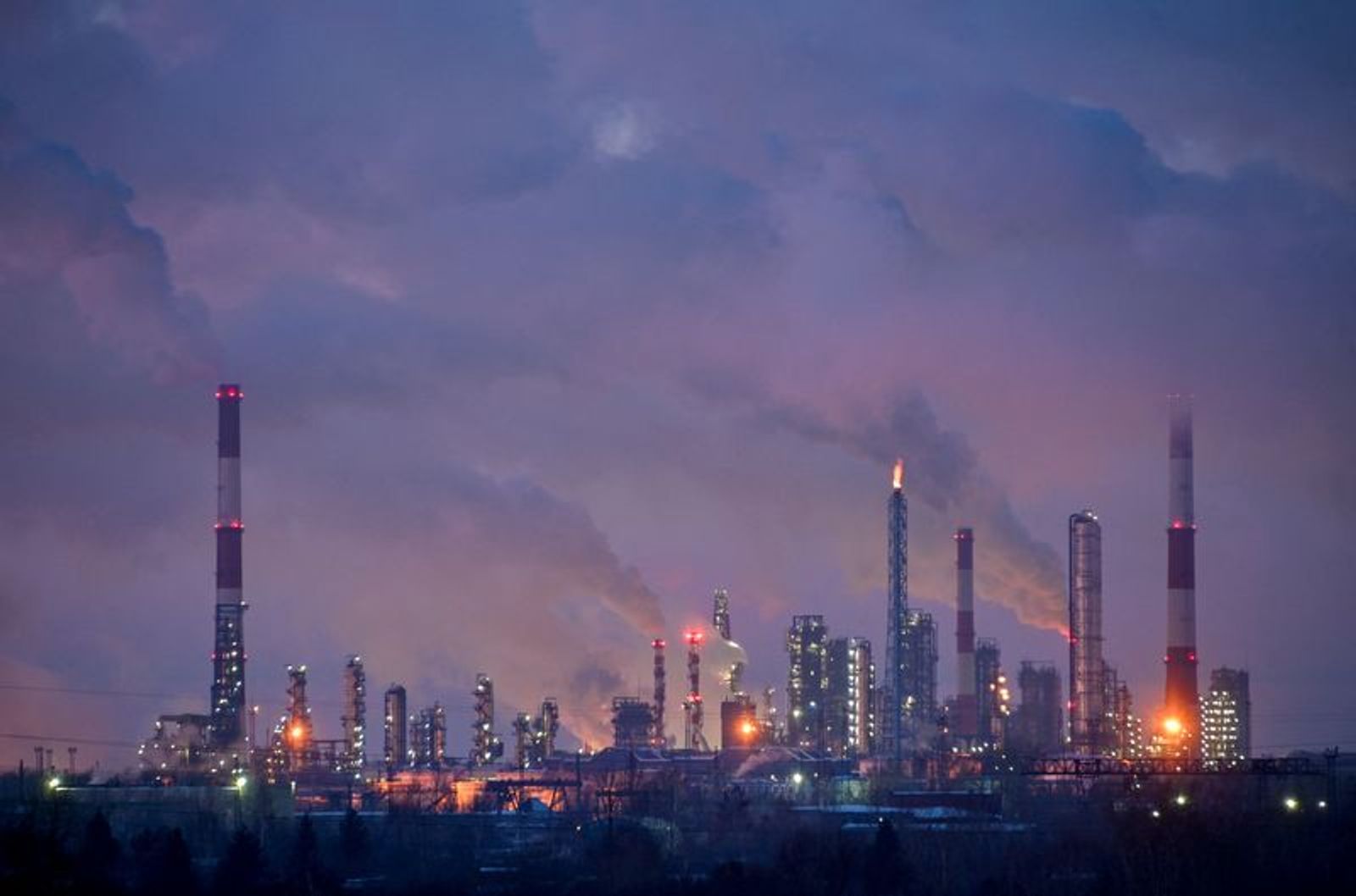 FILE PHOTO: Flue gas and steam rise out of chimneys and smokestacks of an oil refinery during sunset on a frosty day in the Siberian city of Omsk, Russia, February 8, 2023. REUTERS/Alexey Malgavko/File Photo