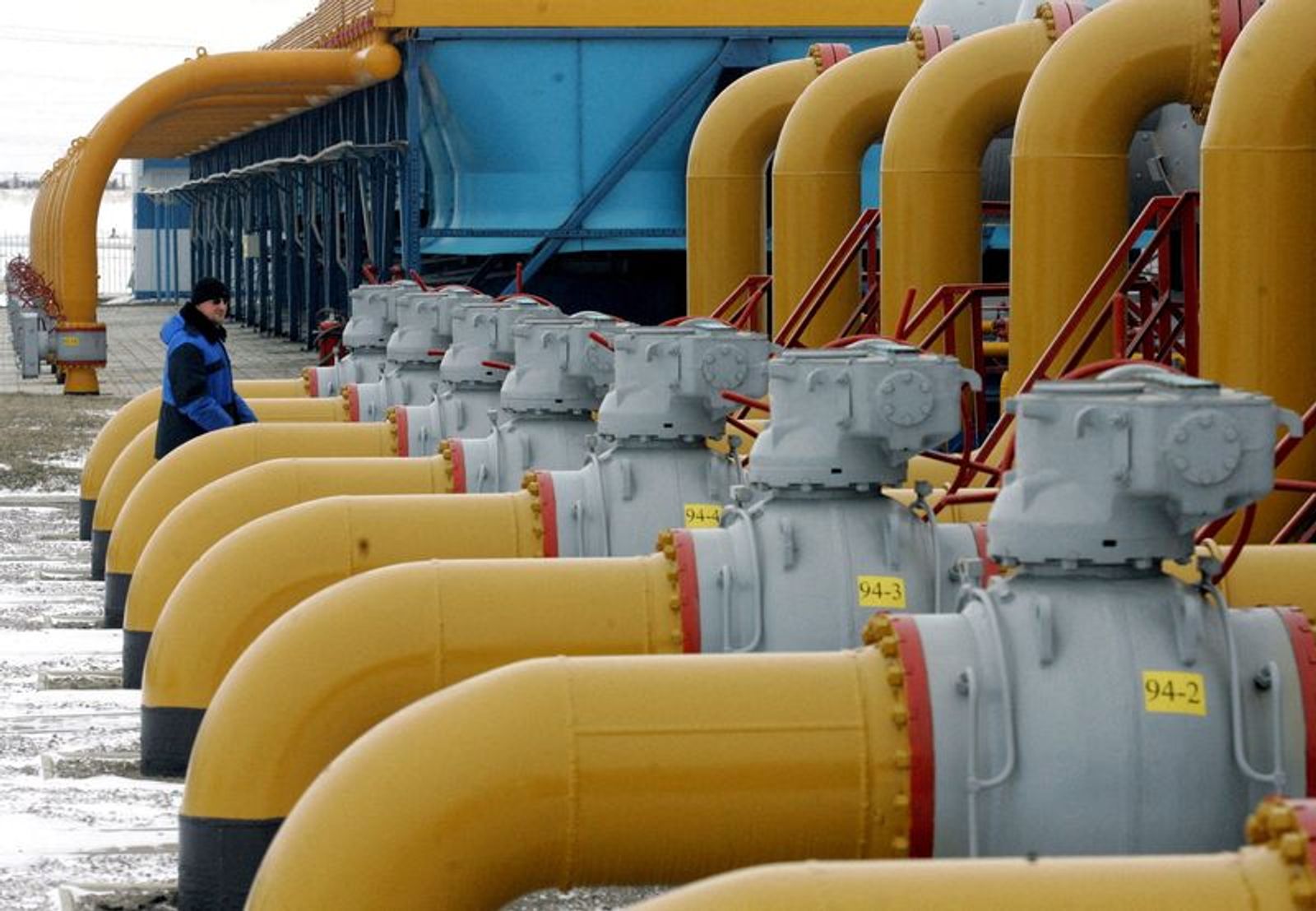 FILE PHOTO: A gas worker walks between pipes in a compressor and distribution station of the Urengoy-Pomary-Uzhgorod gas pipeline, some 30 km (19 miles) from the south western Russian city of Kursk January 4, 2006. REUTERS/Sergei Karpukhin/File Photo